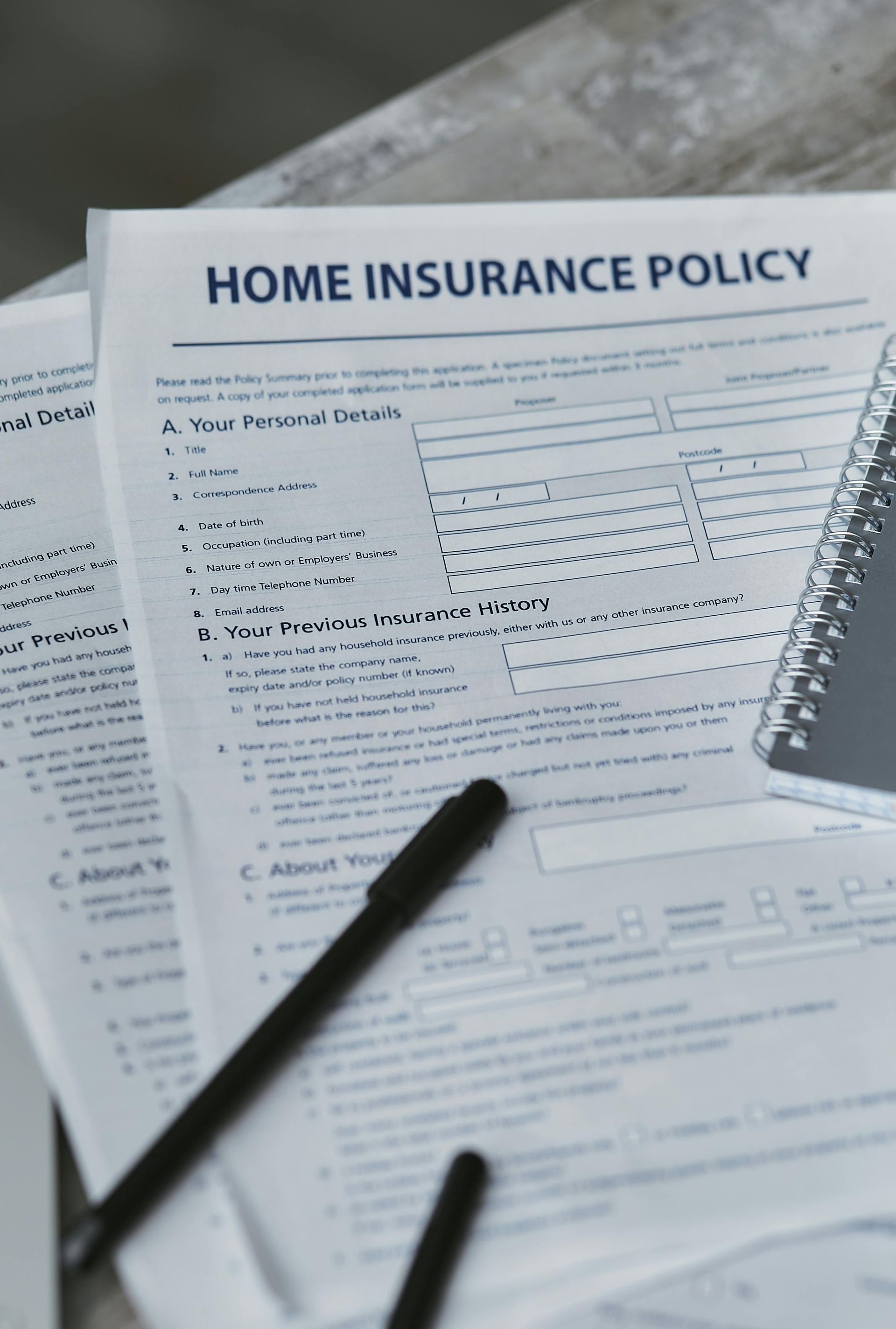 Home insurance policy form with a pen and notepad.