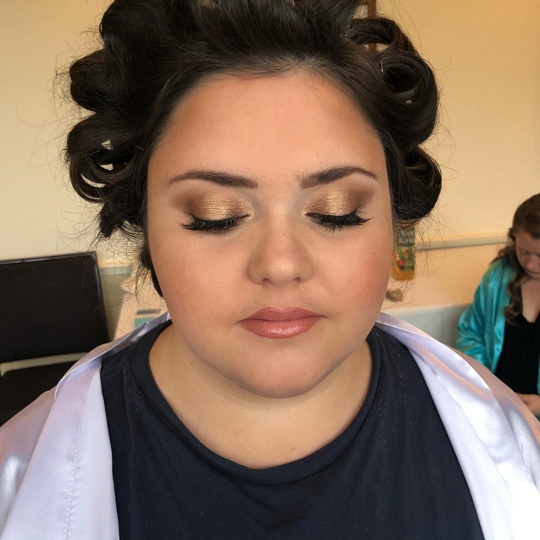 a woman with curlers in her hair is getting her makeup done