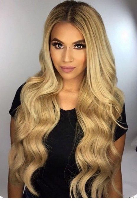 A woman with long blonde hair is wearing a black shirt.