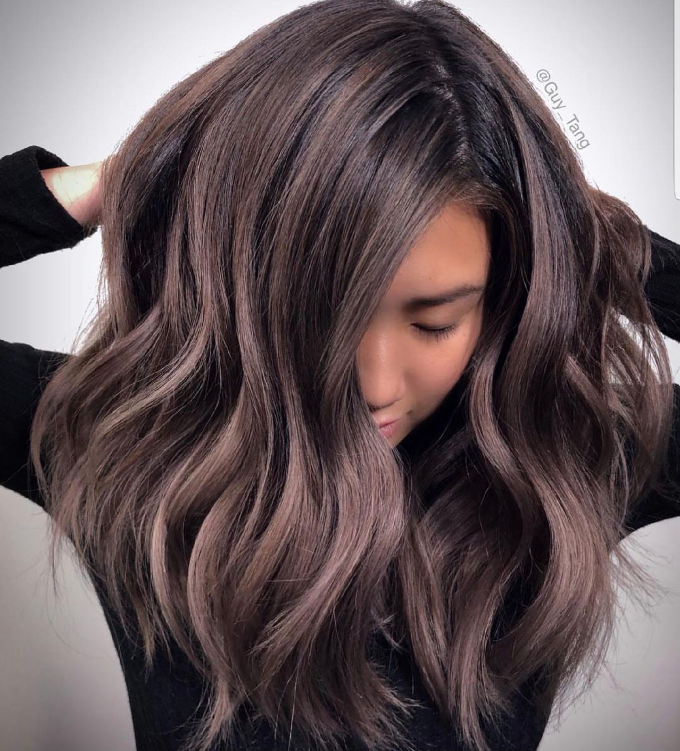 A woman with long brown hair is wearing a black shirt.