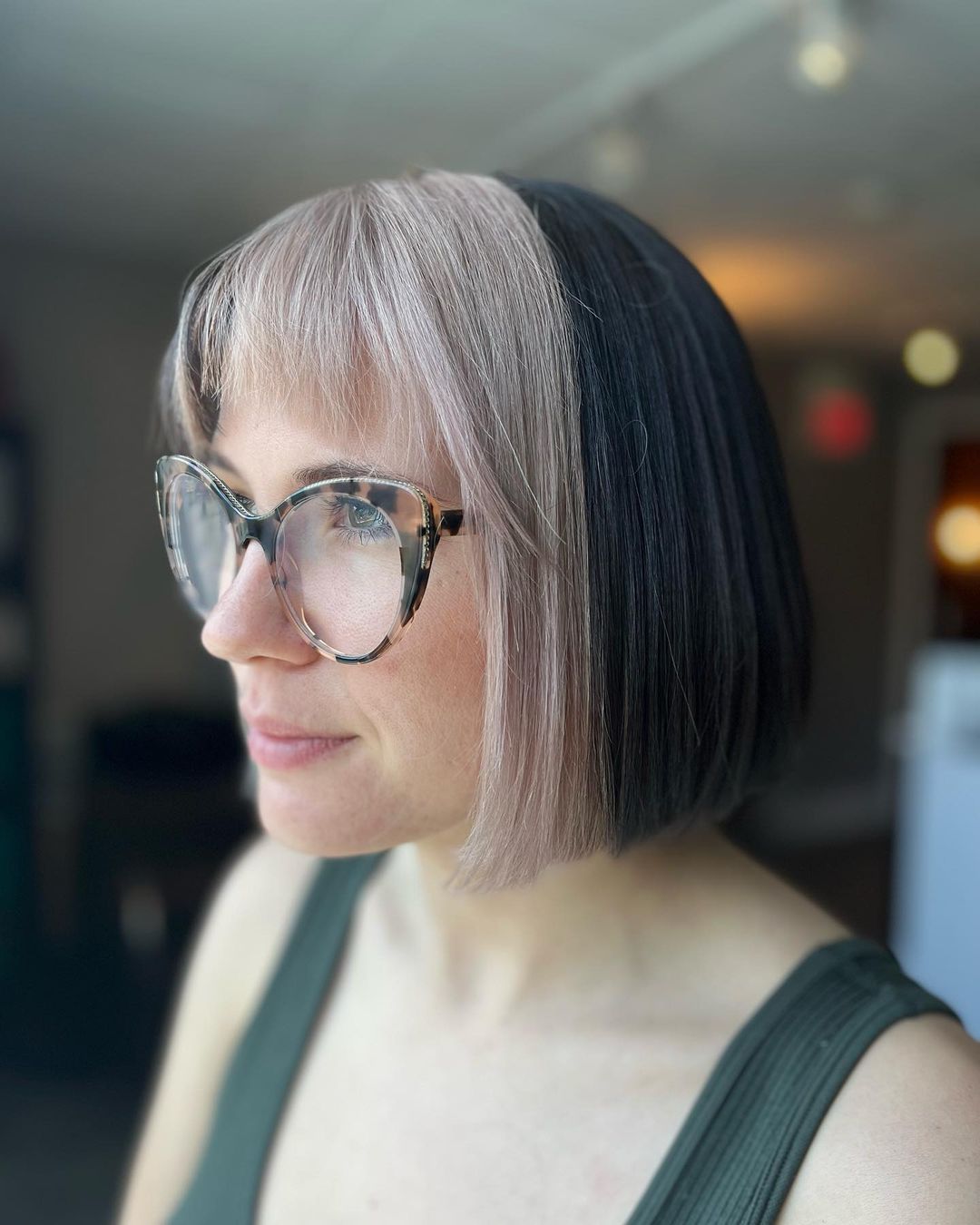 a woman wearing glasses and a green tank top