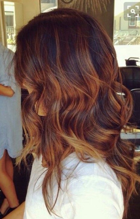 a woman with long brown hair is wearing a white shirt