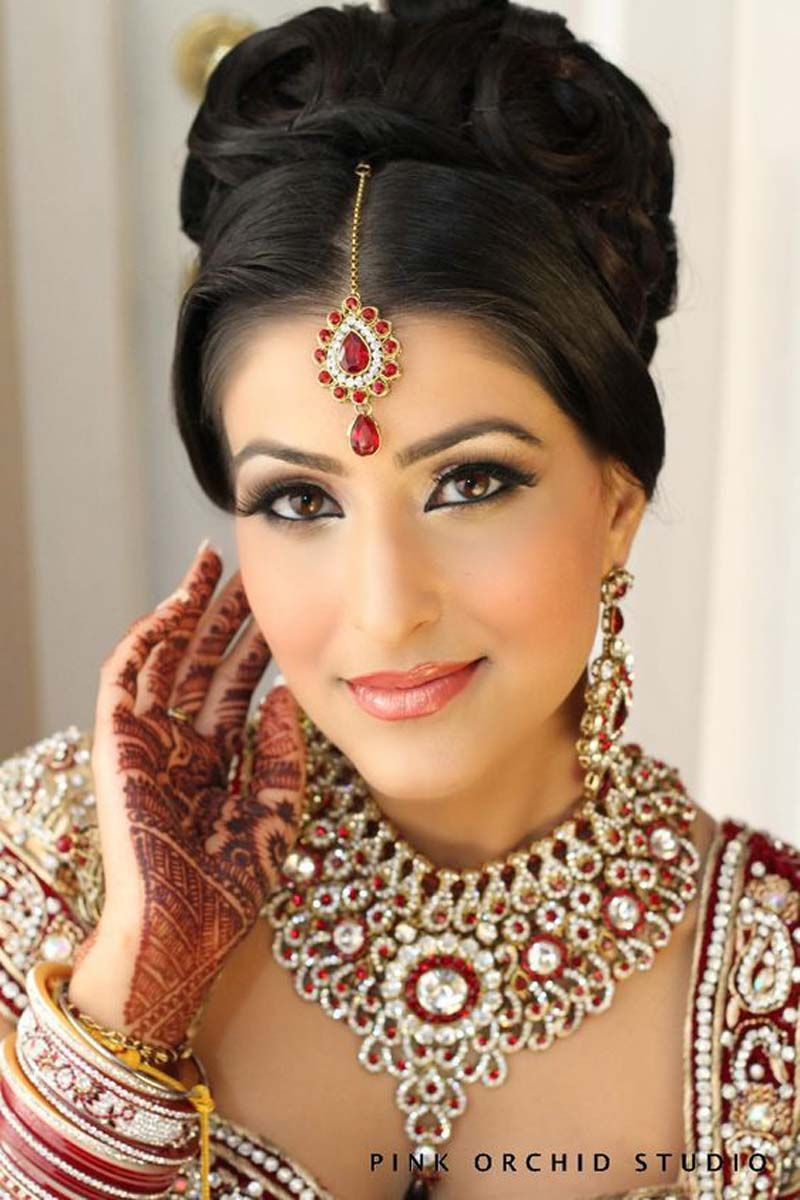 a woman with a henna tattoo on her hand is wearing a necklace and earrings by pink orchid studio