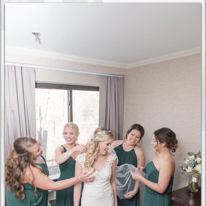 A bride is surrounded by her bridesmaids in green dresses