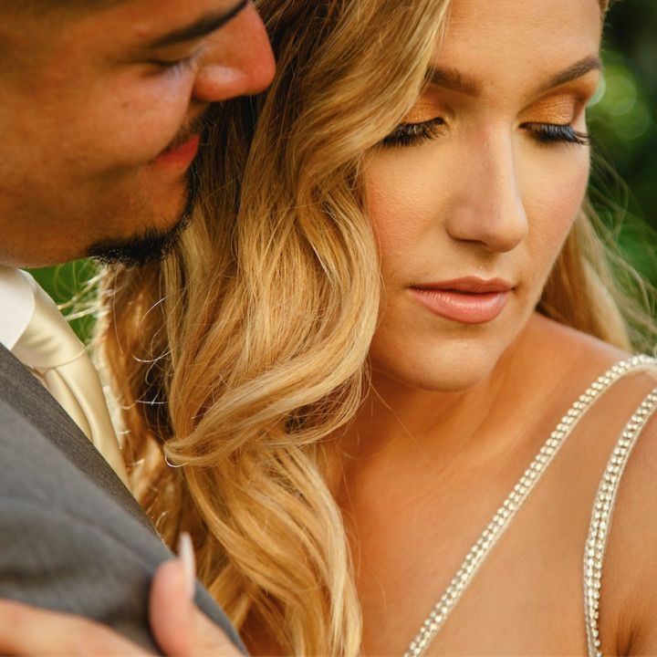 A man in a suit and tie is hugging a woman in a wedding dress