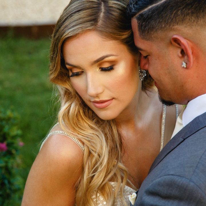 A man in a suit is hugging a woman in a wedding dress