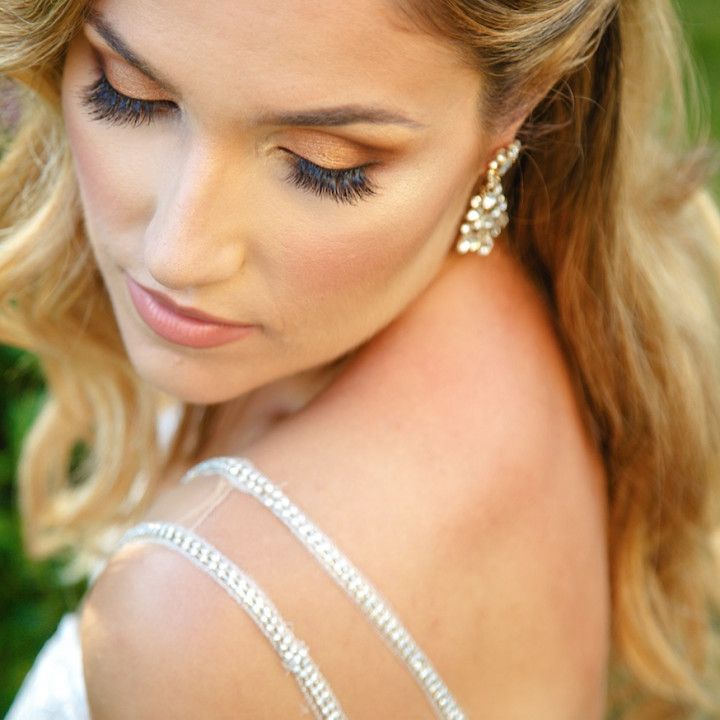 A close up of a woman wearing a white dress and earrings