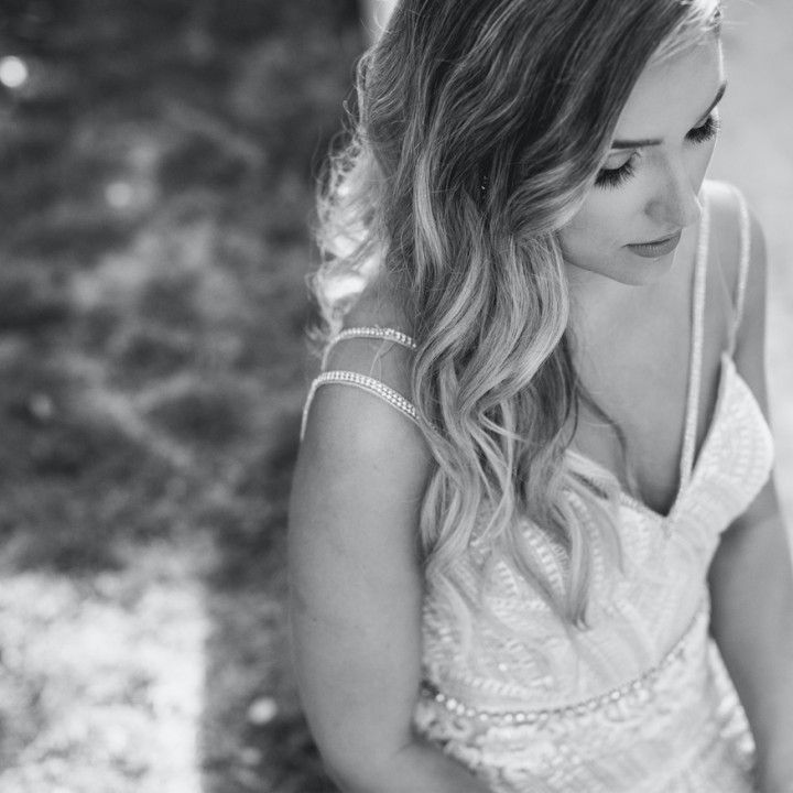 A black and white photo of a woman in a wedding dress looking down.