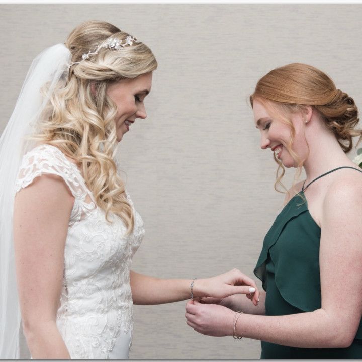 A bride and her bridesmaid are standing next to each other