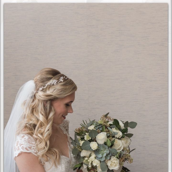 The bride is wearing a veil and holding a bouquet of flowers