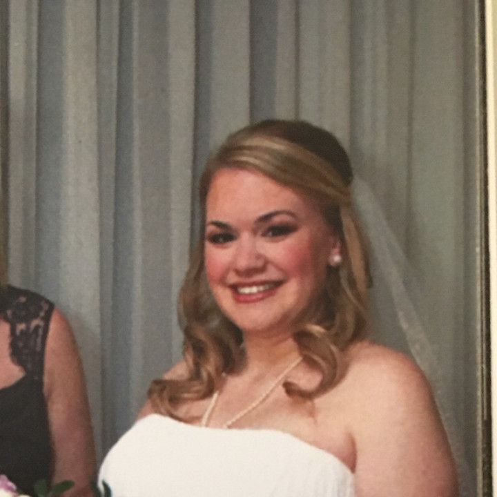 A woman in a wedding dress is smiling for the camera