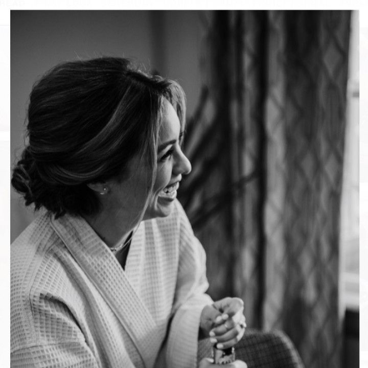 A woman in a robe is smiling in a black and white photo.