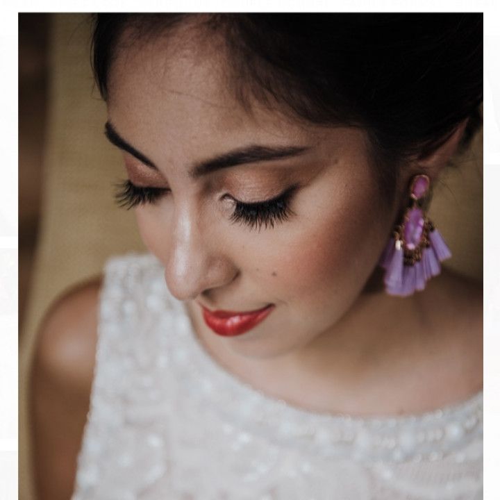 A close up of a woman wearing purple earrings