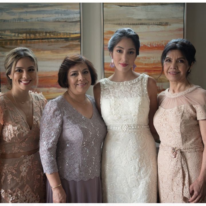A group of women posing for a picture with one wearing a white dress