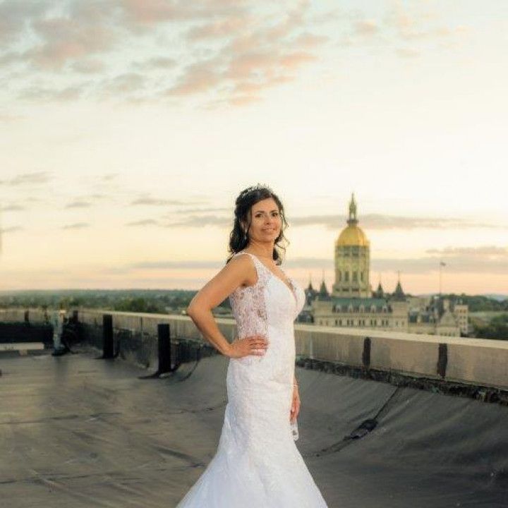 A woman in a wedding dress is standing on a rooftop