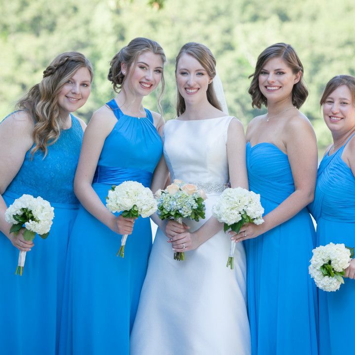 A bride and her bridesmaids are posing for a picture