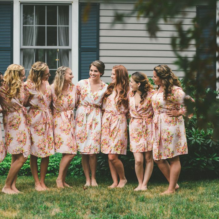A group of bridesmaids are posing for a picture in front of a house.