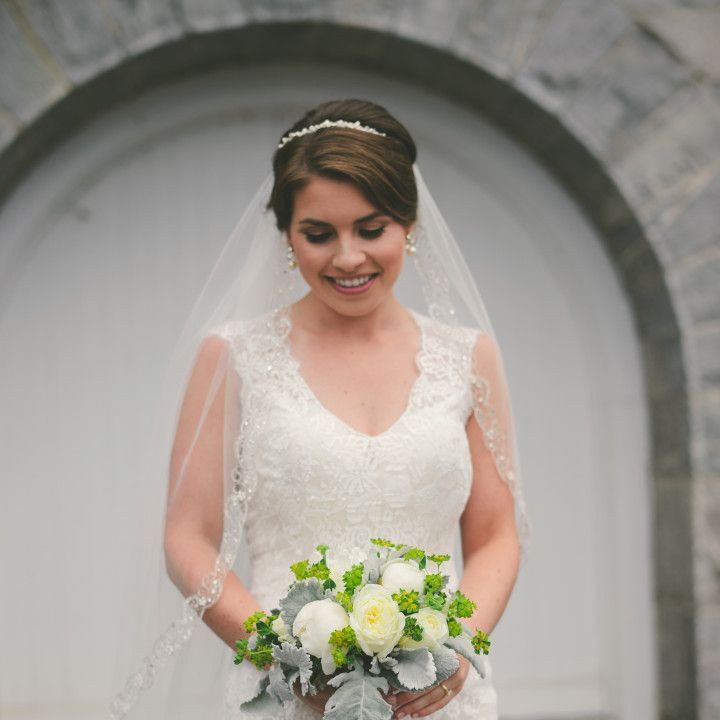 The bride is wearing a veil and holding a bouquet of flowers.