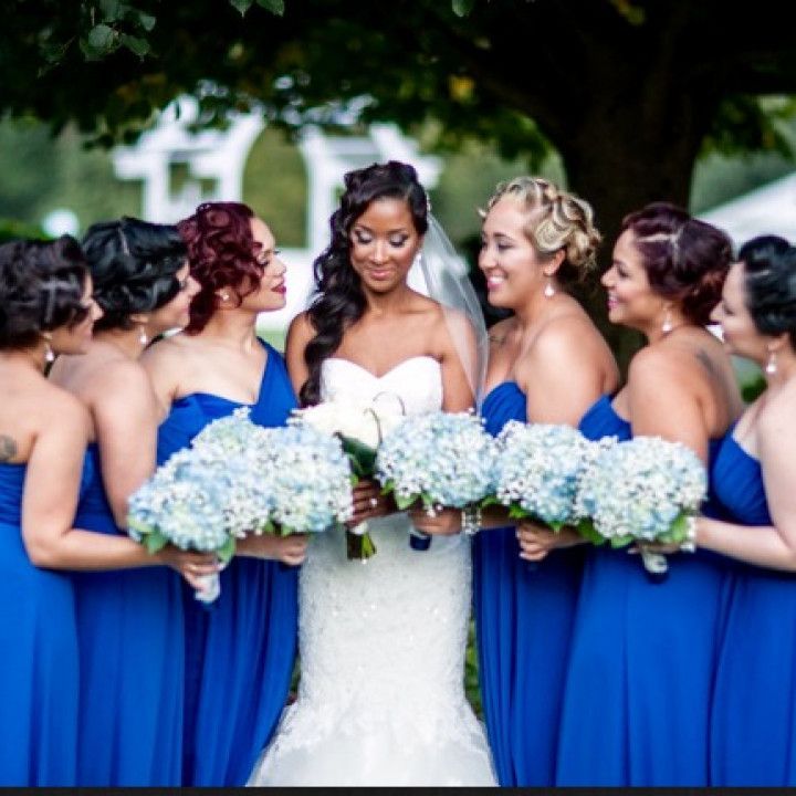 A bride and her bridesmaids are posing for a picture
