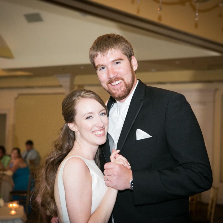 A bride and groom are posing for a picture at their wedding reception