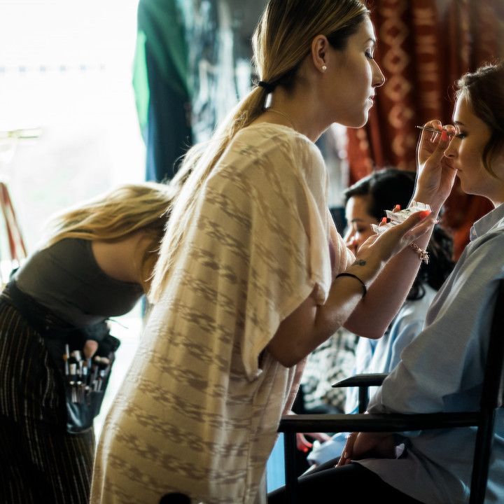 A woman is applying makeup to another woman 's face