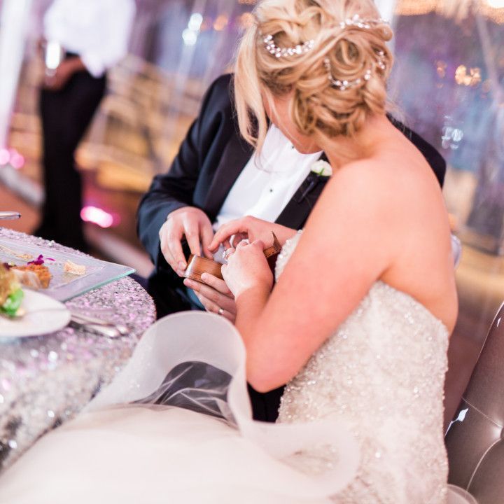 A bride and groom are sitting at a table with food
