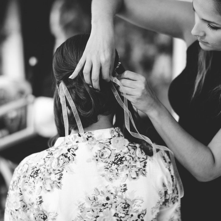 A black and white photo of a woman getting her hair done