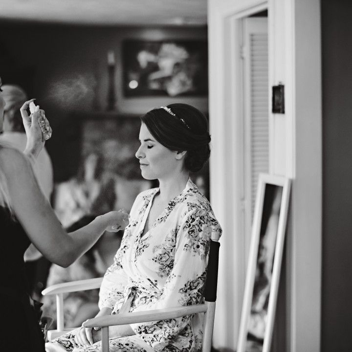 A woman is getting her hair done in a black and white photo.