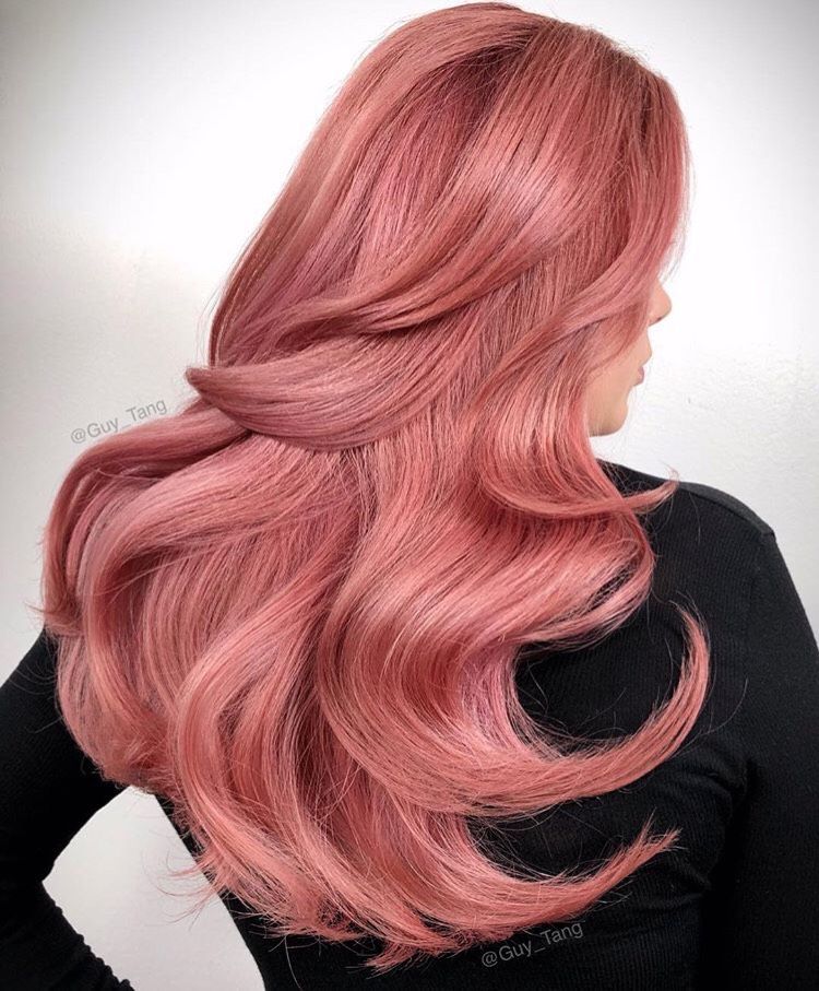 a woman with long pink hair is wearing a black shirt