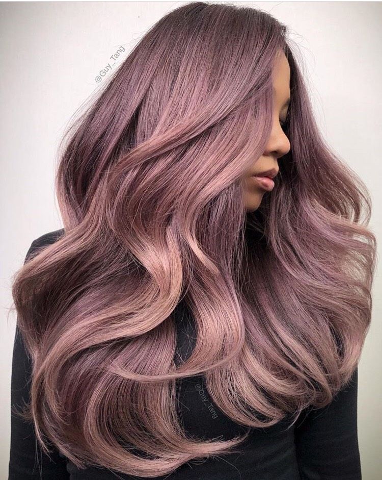 a woman with long purple hair is wearing a black shirt