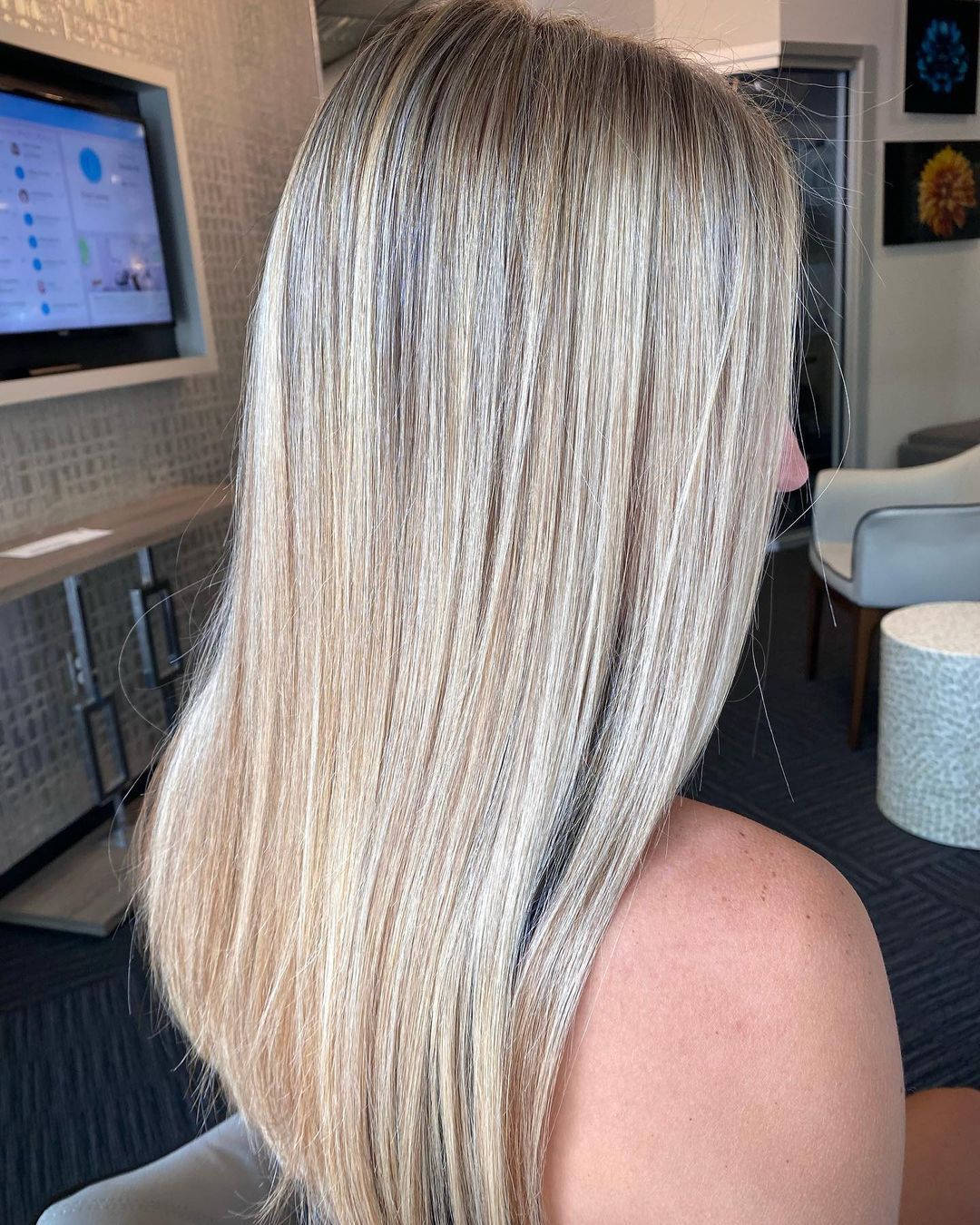a woman with blonde hair is sitting in front of a tv