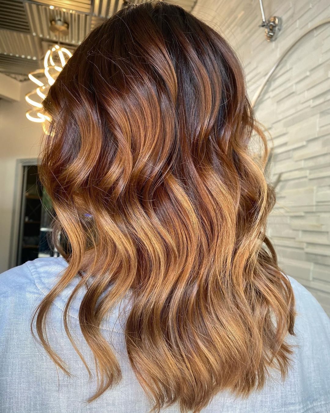 the back of a woman 's head with long brown hair