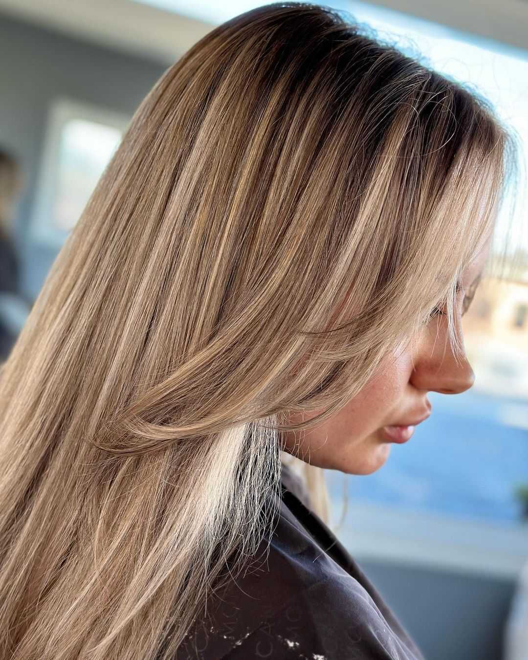 a woman with long blonde hair is wearing a black cape