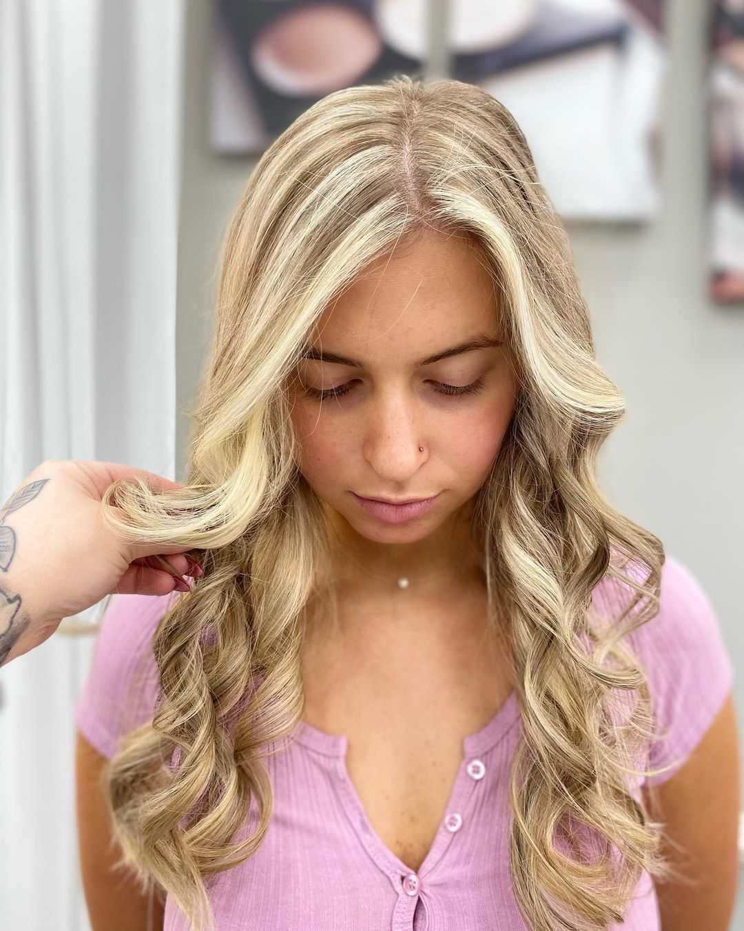 a woman with blonde hair is wearing a pink shirt