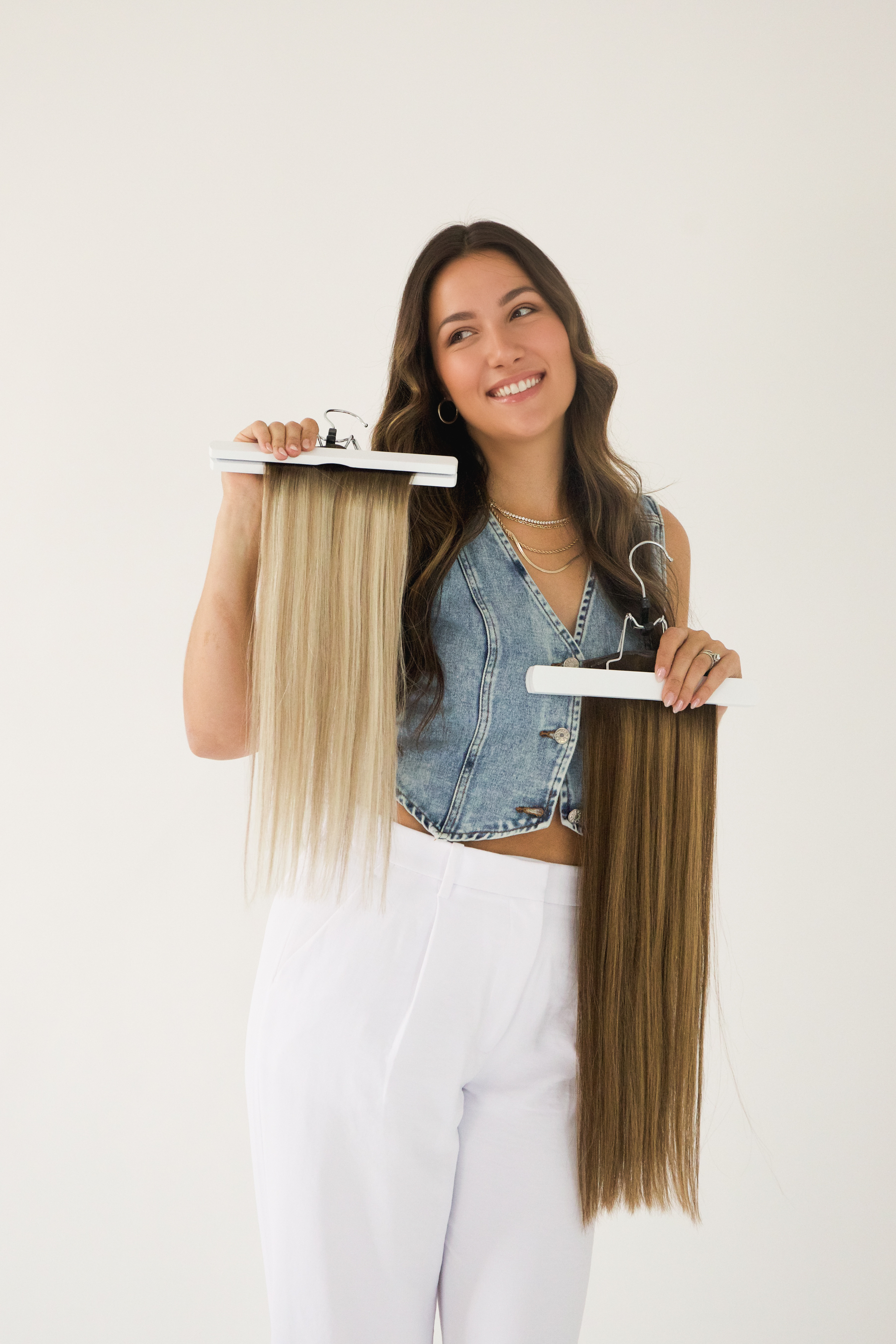 A woman is holding two pieces of hair in her hands.