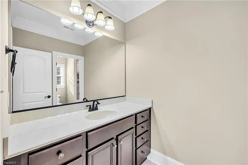A bathroom with a large mirror and a sink.