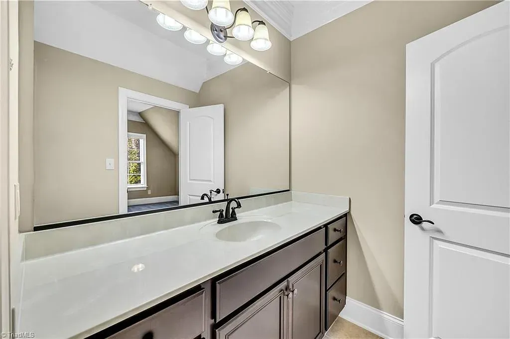 A bathroom with a sink and a large mirror.
