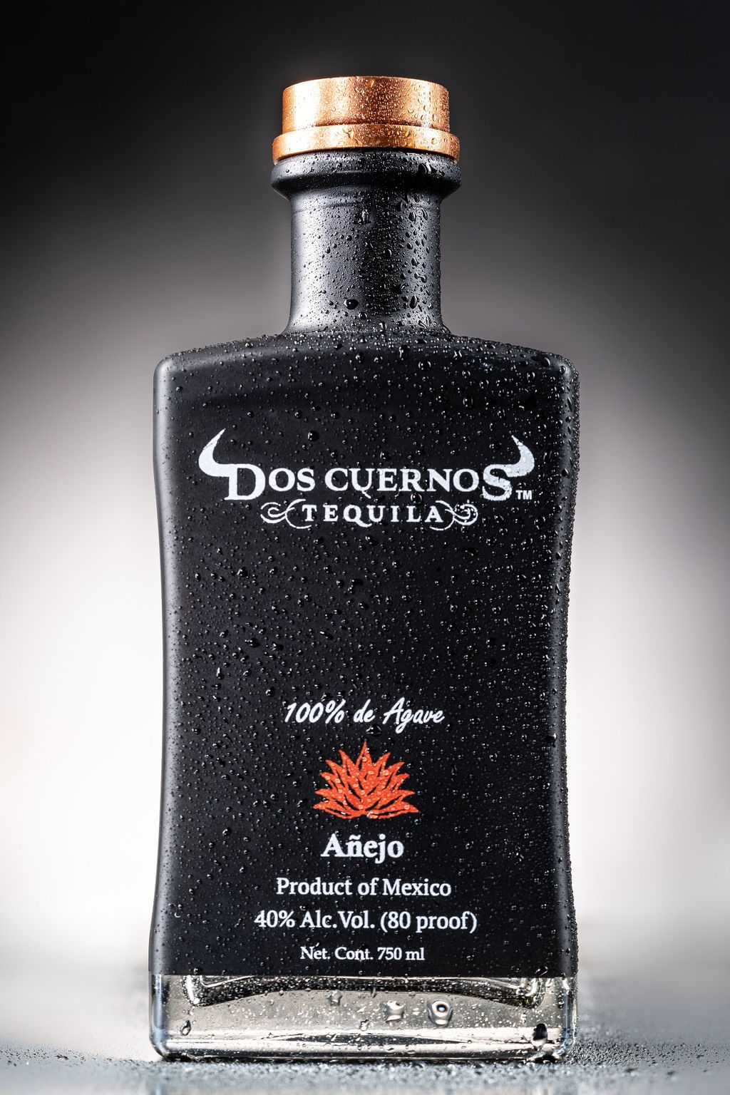 A bottle of dos cuernos tequila is sitting on a table.