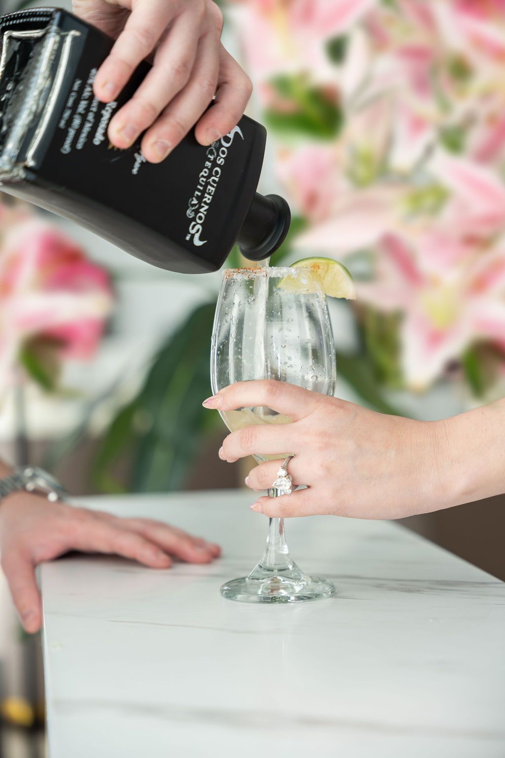 A person is pouring champagne into a glass on a table.