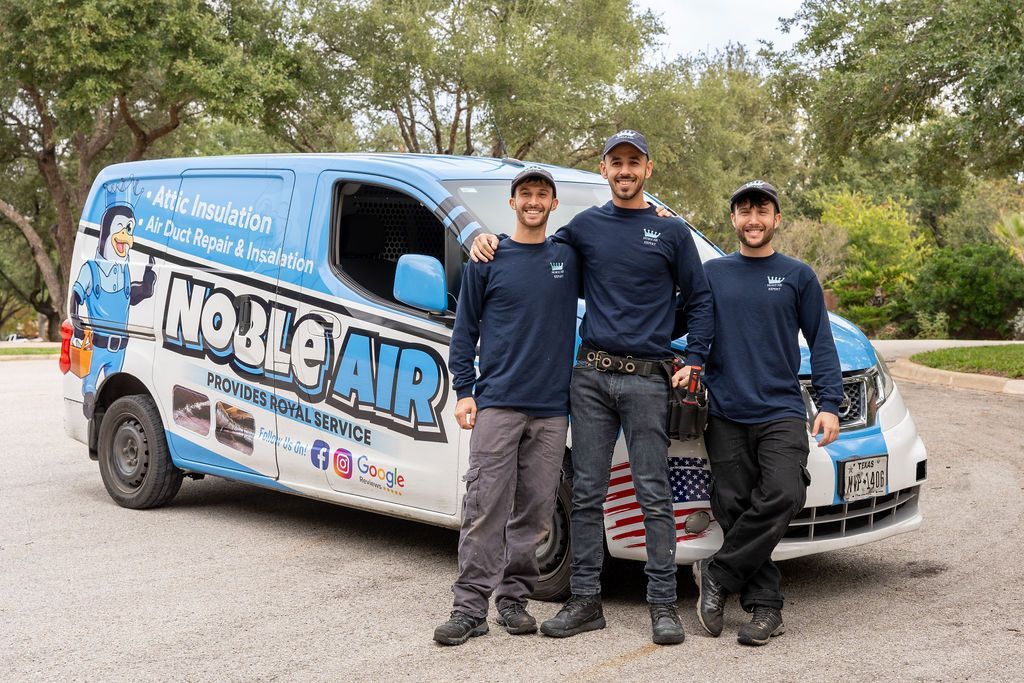 Three men are posing for a picture in front of a van.