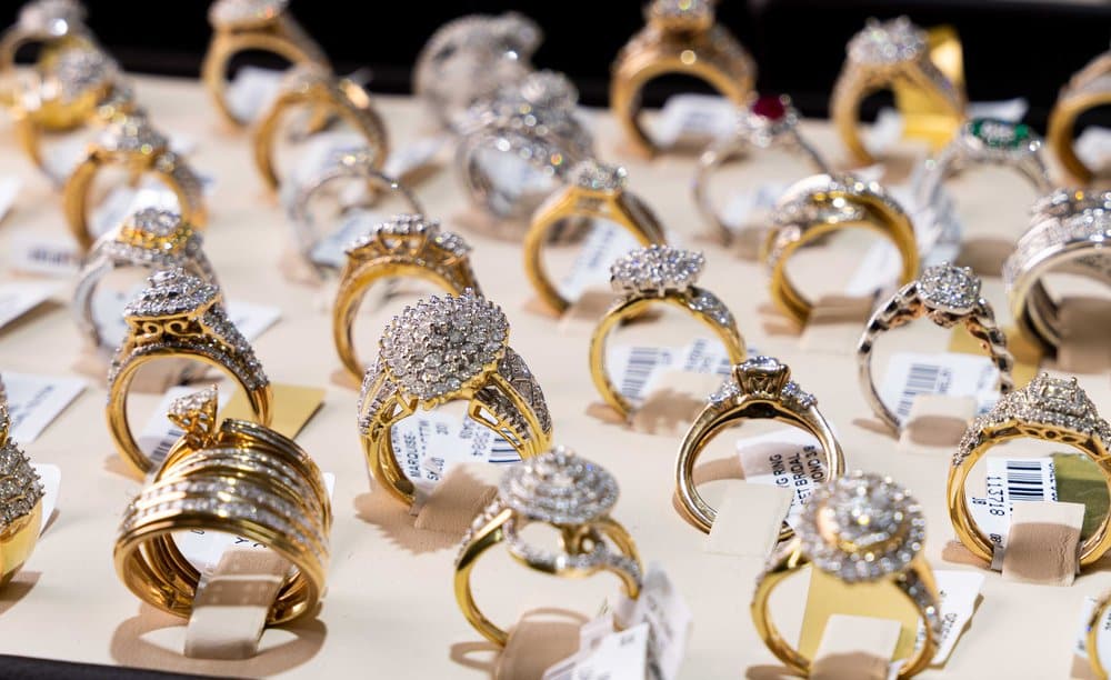 A variety of gold and diamond rings are displayed on a table.