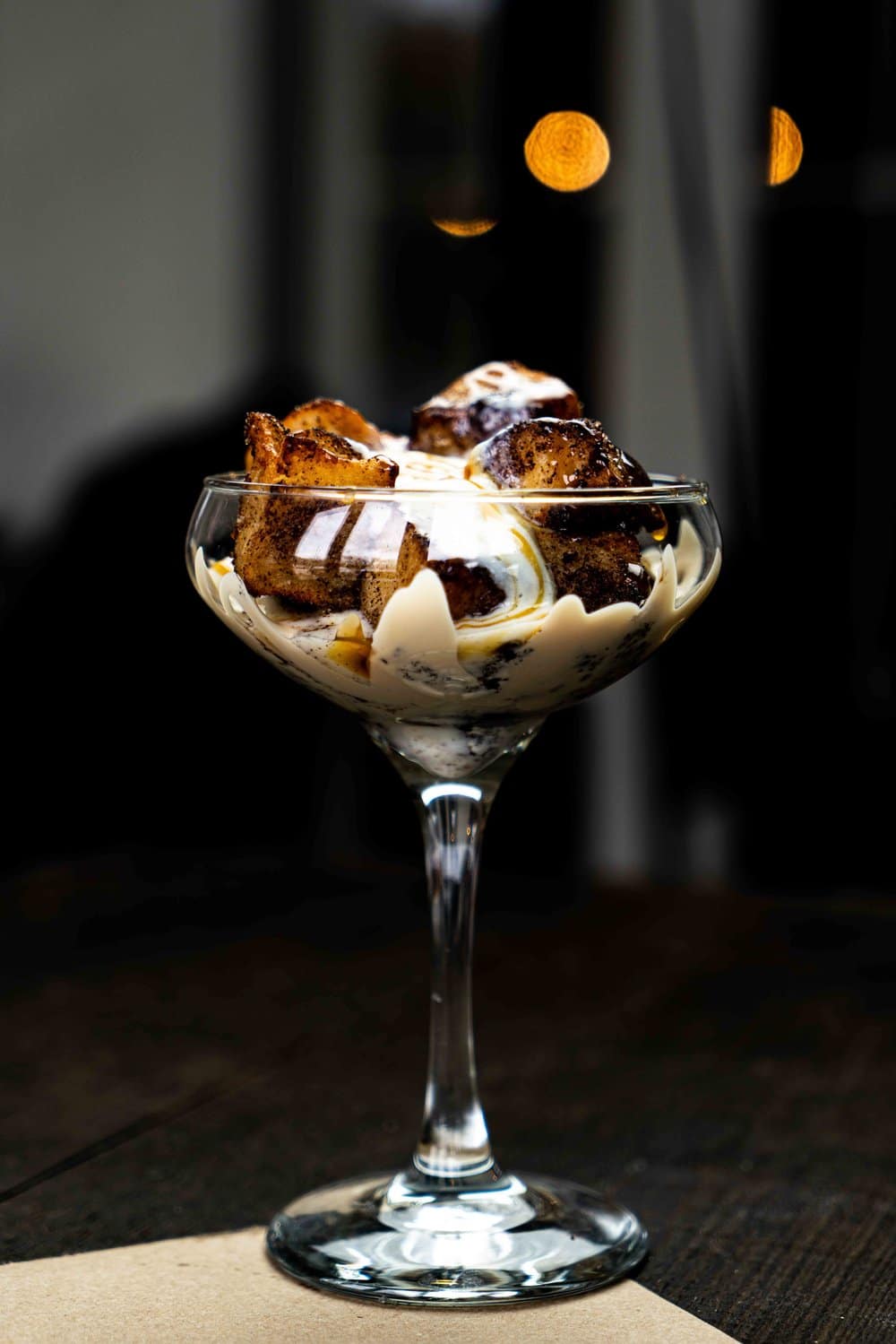 A close up of a dessert in a martini glass on a table.