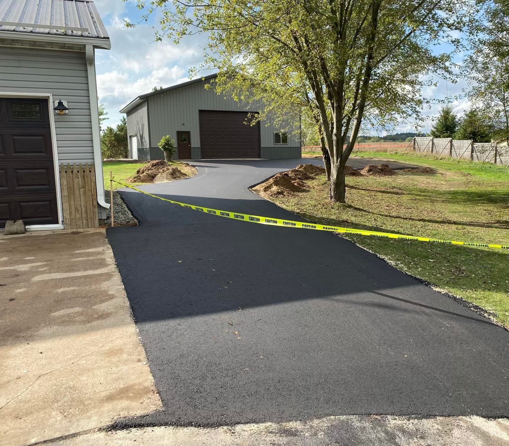 A driveway leading to a garage with a building in the background