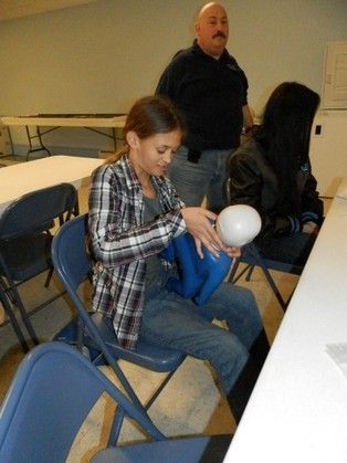 A girl is sitting in a chair holding a balloon