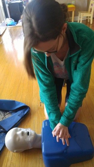 A woman is doing a heart massage on a mannequin.
