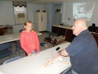 A man and a girl are sitting at a table with a doll on it.