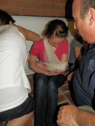 A woman with a bandage on her arm sits next to a man