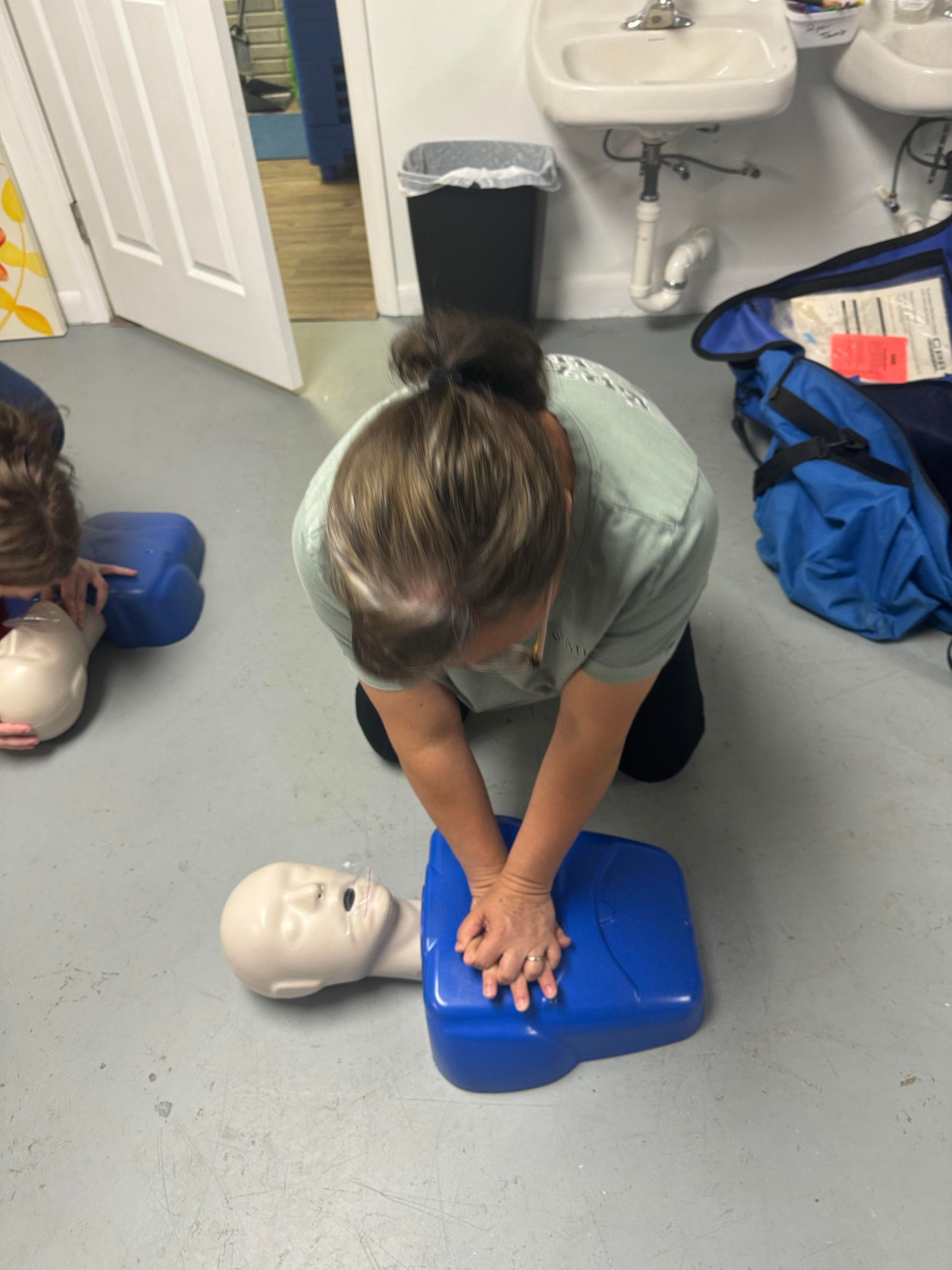 A woman is doing a heart massage on a mannequin.