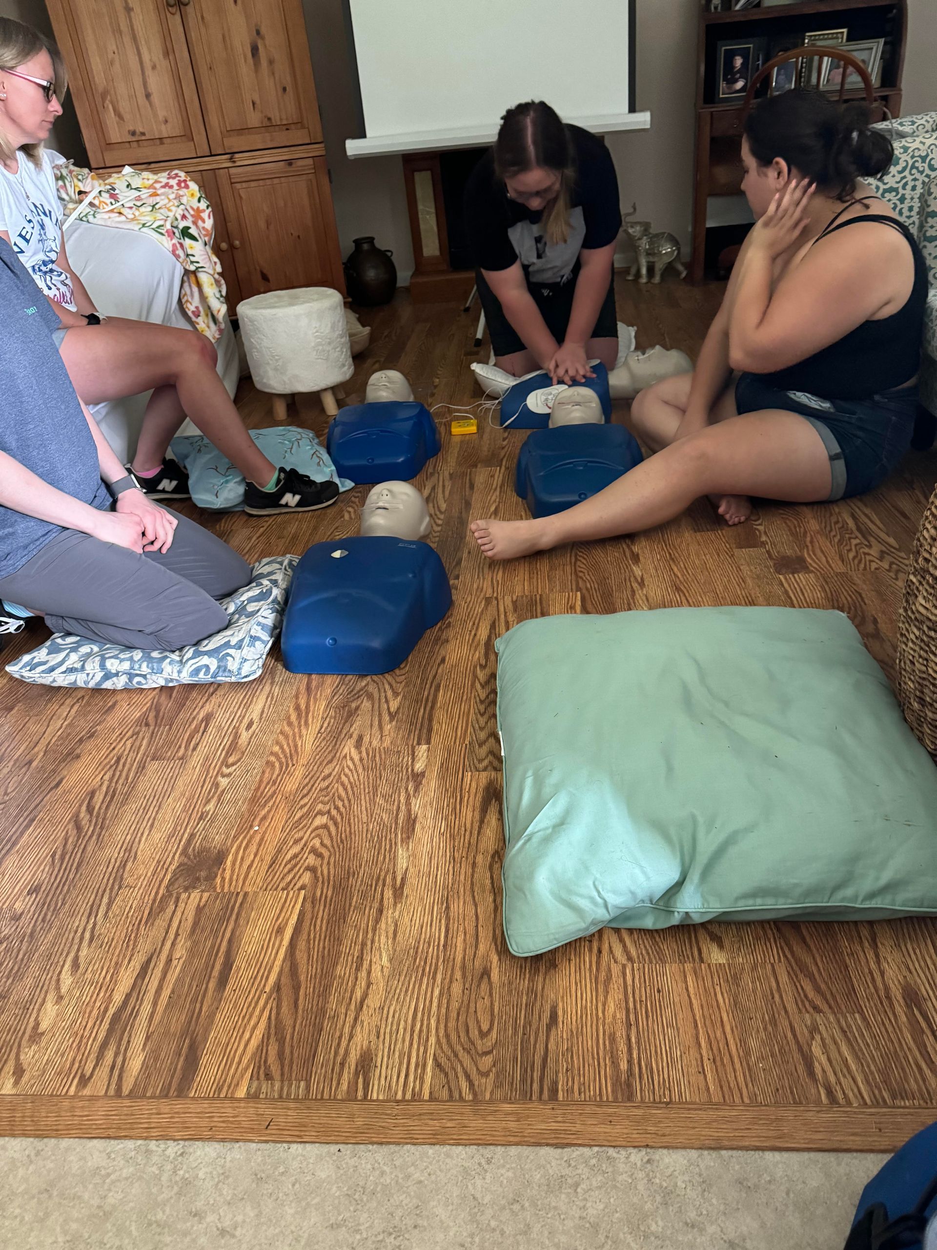 A group of people are sitting on the floor in a living room