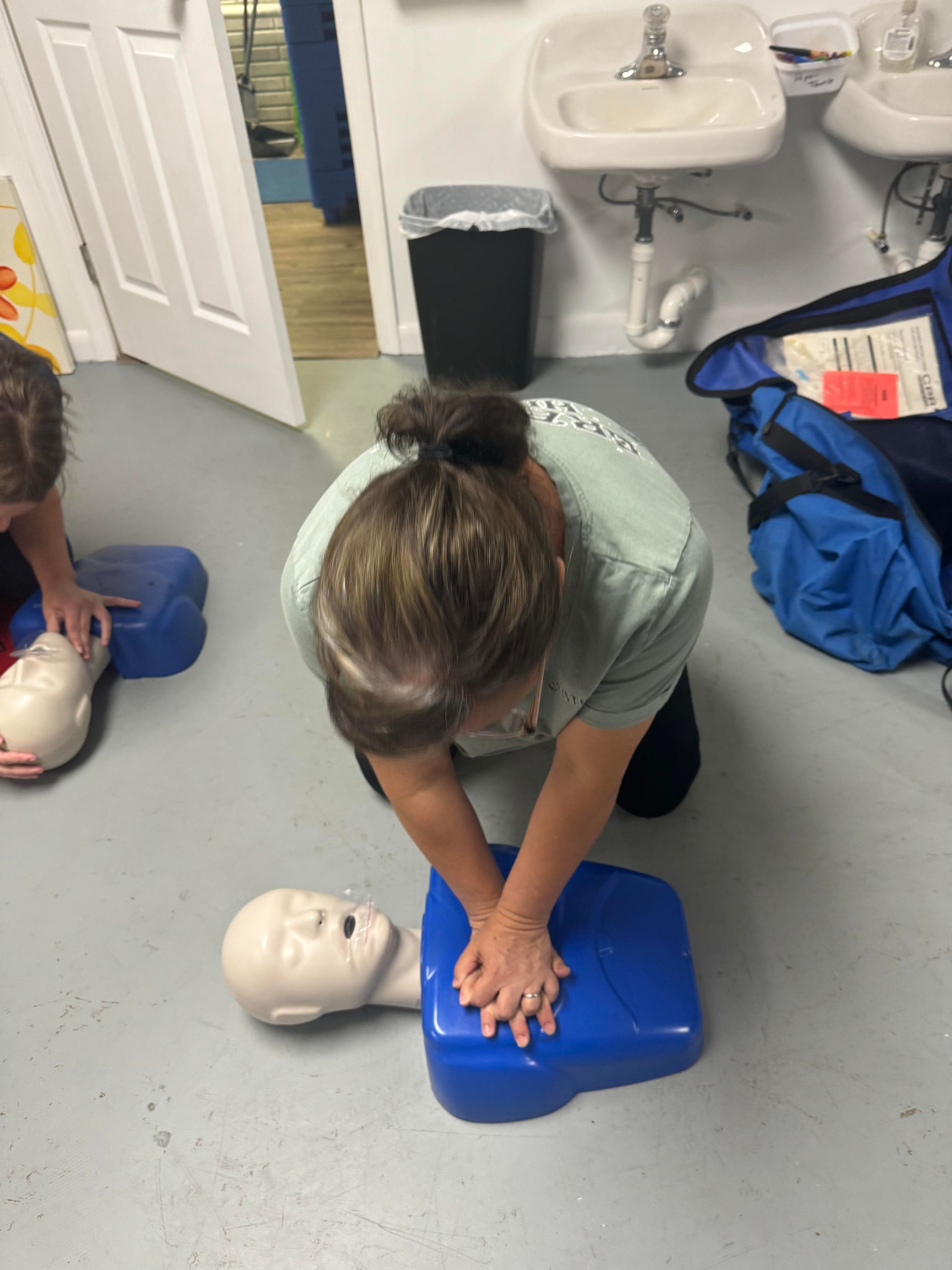 A woman is doing a heart massage on a mannequin.